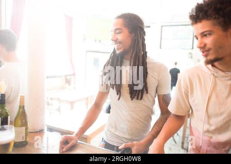 Zwei Männer lächeln an einer Bar. Stockfoto