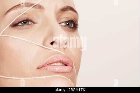 Das Gesicht des jungen Frau eingewickelt in Zeichenkette Stockfoto