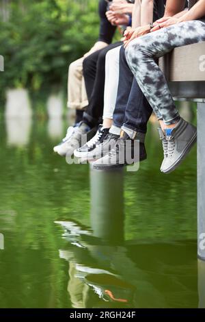 Füße von Teenagern Sneakers tragen am Steg Stockfoto