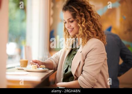 Junge Frau Kuchen Essen im Cafe Stockfoto