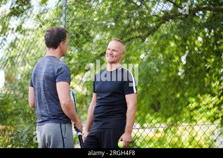 Reife Männer auf dem Tennisplatz Stockfoto