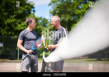 Reife Männer auf dem Tennisplatz Stockfoto