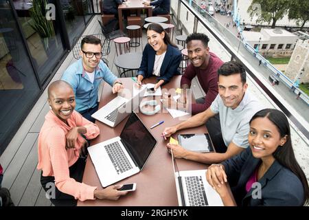 Lächelnd Geschäftsleute mit Laptops während der Sitzung auf dem Balkon Stockfoto