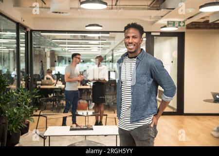 Lächelnde junge Geschäftsmann im Büro Stockfoto