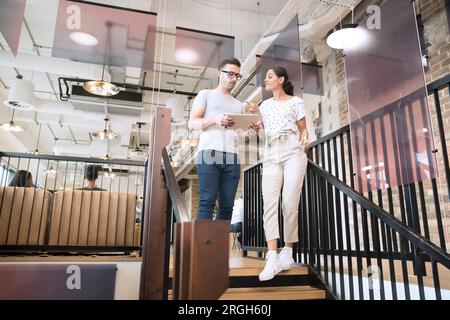 Kollegen mit digitalen Tablette auf Treppe Stockfoto
