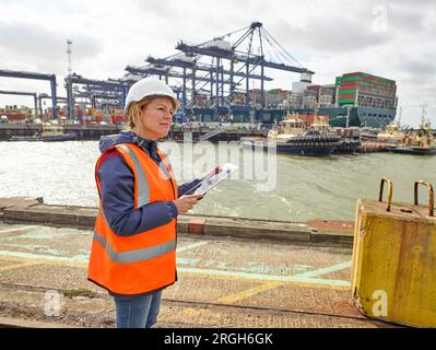 Hafenarbeiter mit digitalen Tablet am Hafen von Felixstowe, England Stockfoto