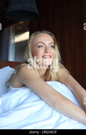 Blonde junge Frau im Bett Stockfoto