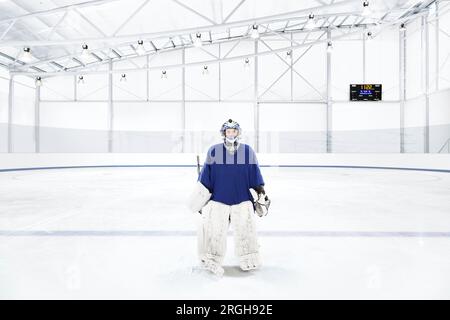 Eishockey Torwart trägt eine blaue Uniform an eine Eisbahn Stockfoto
