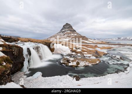 Am Fuße des Wasserfalls Kirkjufellsfoss, der halb vereist ist und nicht so viel Wasser durchfließt wie im Sommer. Stockfoto