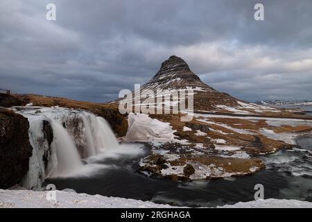 Am Fuße des Wasserfalls Kirkjufellsfoss, der halb vereist ist und nicht so viel Wasser durchfließt wie im Sommer. Stockfoto