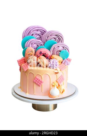 Rosafarbener Kuchen dekoriert mit bunten Lollipops, Donuts, Eis am Stiel, Baiser-Wirbeln, Schokoriegeln und goldenen Sternen. Isoliert auf weißem Hintergrund Stockfoto