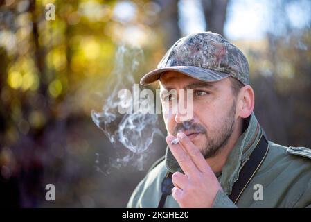 Porträt eines jungen Mannes mit einer Zigarette, Rauchen Zigaretten schlechte Angewohnheit Konzept Stockfoto