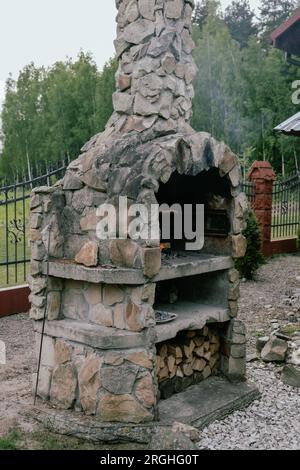 Holzgrill aus Steinsteinen, Grillen im Garten. Stockfoto