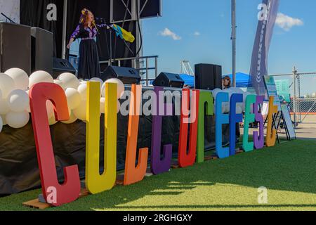 Saint John, NB, Kanada - 6. August 2023: Ein Künstler singt und winkt beim International Culture Fest, einer kostenlosen Veranstaltung ohne Eintrittskarte, mit einer ukrainischen Flagge. Stockfoto