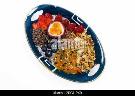 chiapudding-Frühstück mit Passionsfrüchten, Nüssen und Beeren isoliert mit weißem Hintergrund Stockfoto