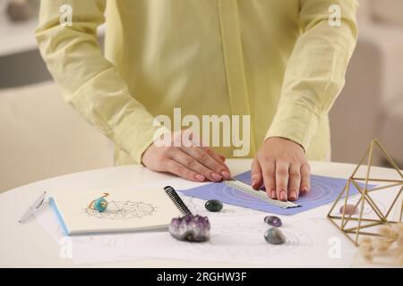 Astrologe benutzt Zodiac-Rad für die Geschichtsvorhersage am Tisch, Nahaufnahme. Das Glück zu erzählen Stockfoto