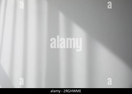 Schatten aus dem Fenster und Vorhänge an der weißen Wand Stockfoto