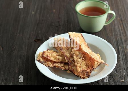 Verkauf Pisang Goreng, gebratene, knusprige, getrocknete Banane mit Mehlbeschichtung. Serviert mit Tee. Traditioneller indonesischer Snack Stockfoto