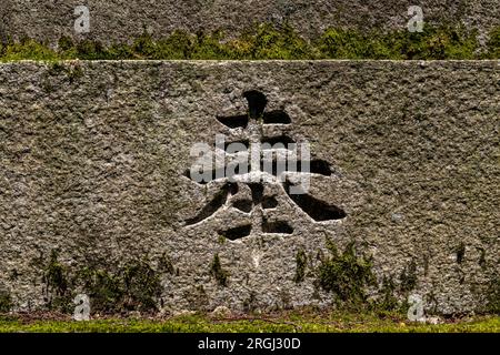 Steinschnitzerei im Schrein des japanischen Kanji-Charakters. ÜBERSETZUNG: Einhaltung, Angebot, anwesend, engagiert. In diesem Zusammenhang heißt es "hou". Stockfoto