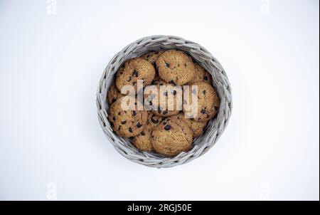 Schokoladenkekse in einem Bambuskorb isoliert auf weißem Hintergrund Stockfoto
