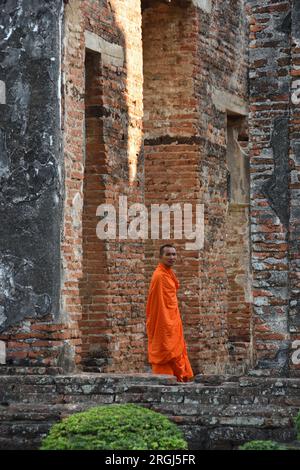 Der thailändische buddhistische Mönch schaut auf die Kamera. Der Mönch war in der Dusit Sawan Halle, dem König Narai Palast, Lopburi, Thailand Stockfoto