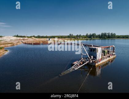 Saugbaggerschiffe ziehen Schlamm auf dem Fluss an Stockfoto