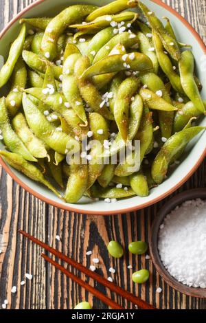 Scharfe gegrillte Edamame-Sojabohnen mit Meersalz auf dem Teller auf dem Tisch. Vertikale Draufsicht von oben Stockfoto