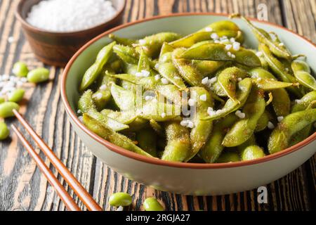 Gebratene grüne Sojabohnen Edamam gewürzter Knoblauch und Salz auf dem Teller auf dem Tisch. Horizontal Stockfoto