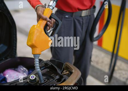 Nahaufnahme der Handhaltedüse zum Einfüllen von Öl in den Motorradtank. Transport- und Energiekonzept. Stockfoto