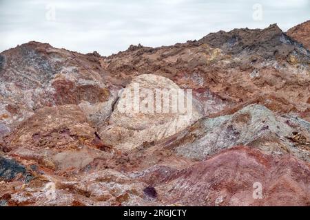 Salines Berge. Halite-Deposinen. Schlammvulkan (Salse) in der Mitte. Dünne Vegetation. Vulkanischer Ursprung auf der Insel Ormuz. Stockfoto