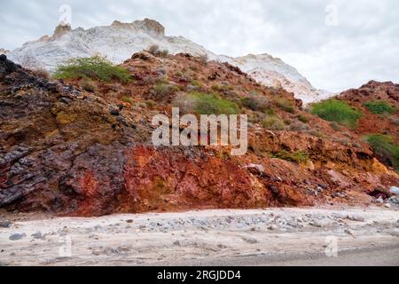 Salines Berge. Halite-Deposinen. Schlammvulkan (Salse) in der Mitte. Dünne Vegetation. Vulkanischer Ursprung auf der Insel Ormuz. Stockfoto