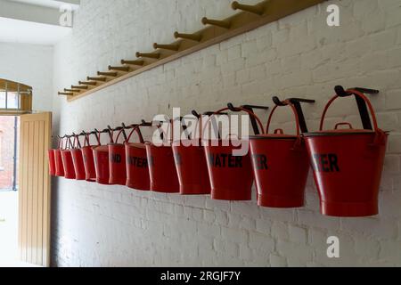 Eine Reihe roter Feuereimer Wasser und Sand im Fort Nelson Royal Armouries Hampshire England Stockfoto