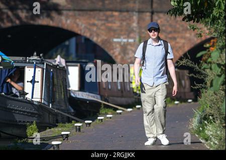 Brindley Place Birmingham, 10. August 2023: In Birmingham haben sich die Menschen in der heißen Morgensonne sportlich betätigt, bevor die Temperaturen in Midlands-Stadt voraussichtlich 26 Grad erreichen werden. Ein Hund namens Dash durfte sogar unter einem Sonnenschirm auf seinem Kanalboot sitzen und eine Kaugummi essen. Kredit: Stop Press Media/Alamy Live News Stockfoto