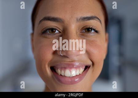 Porträt einer glücklichen birassischen Ärztin mit Nasenpiercing im Korridor des Krankenhauses Stockfoto