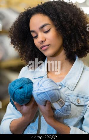 Frau wählt verschiedene Garne für die Näharbeit Stockfoto