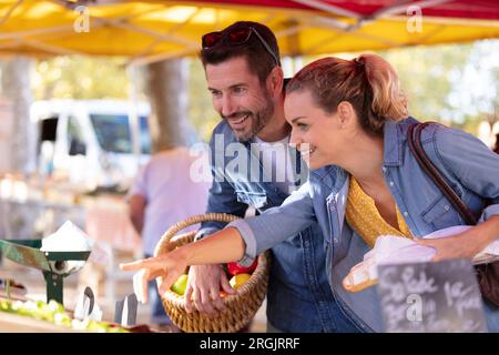 Ein paar Touristen, die sich Produkte auf dem lokalen Markt ansehen Stockfoto