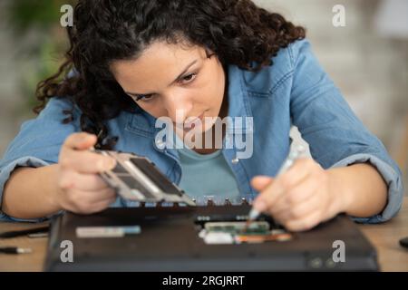 Nahaufnahme eines Technikers, der den Laptop am Schreibtisch repariert Stockfoto