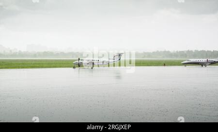 Beechcraft King Air (UR-CWA) auf dem Vorfeld des internationalen Flughafens Kiew (Zhuliany) bei starkem Regen. Stockfoto