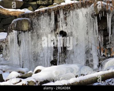 Winter-Wasserfall umgeben mit bläulichen Eiszapfen Stockfoto