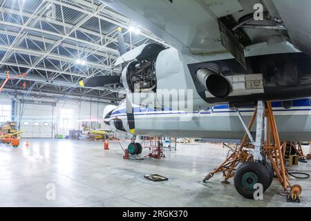 Turboprop-Flugzeug im Hangar transportieren. Luftfahrzeuge werden gewartet. Überprüfung der mechanischen Systeme für den Flugbetrieb Stockfoto