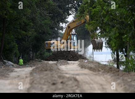 (230810) -- TIANJIN, 10. August 2023 (Xinhua) -- Ein Arbeiter betreibt eine Maschine zur Verstärkung eines Deichs im Bezirk Jinghai, nordchinesische Gemeinde Tianjin, 10. August 2023. Die lokalen Behörden haben die Hochwasserkontrolle und Katastrophenhilfe im Taitou-Abschnitt des Daqinghe-Flusses im Bezirk Jinghai der Gemeinde Tianjin in Nordchina fortgesetzt und den Bezirk auf Notfälle vorbereitet. (Xinhua/Zhao Zishuo) Stockfoto