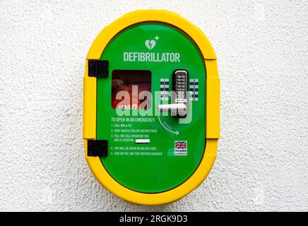 Querformat vor einer weißen Wand eines automatisierten externen Defibrillators oder AED, der dort aufbewahrt wird, wo medizinisches Fachpersonal und Ersthelfer ihn verwenden können Stockfoto