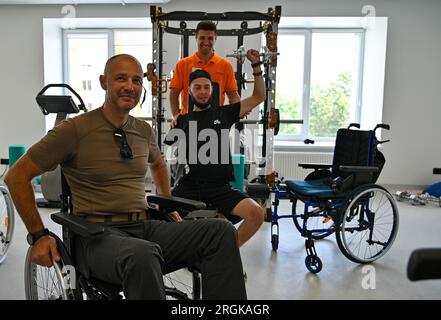 LEMBERG, UKRAINE - 9. AUGUST 2023 - ein Unternehmer (L) fährt im Rollstuhl im Rahmen eines Experiments durch das Superhumans Center, Lemberg, Westukraine Stockfoto