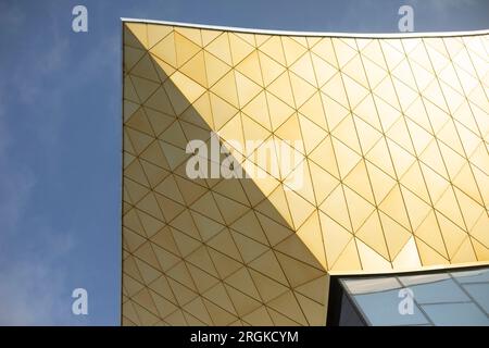 Modernes Gebäude aus Glas und Metall. Goldene Farbe in der Architektur des Gebäudes. Modernes Gebäude. Oberfläche im Palast spiegeln. Stockfoto