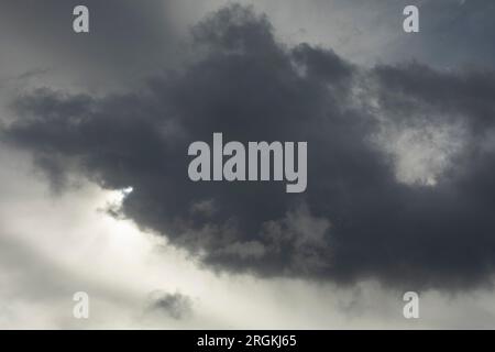 Wolke verdeckt die Sonne. Grauer Himmel. Wolkiges Wetter. Tragischer Himmel über dem Wald. Stockfoto