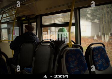 Leute im Bus. Passagiere sitzen während des Transports auf den Sitzen. Innerhalb der öffentlichen Verkehrsmittel. Sitzplätze im Bus. Stockfoto