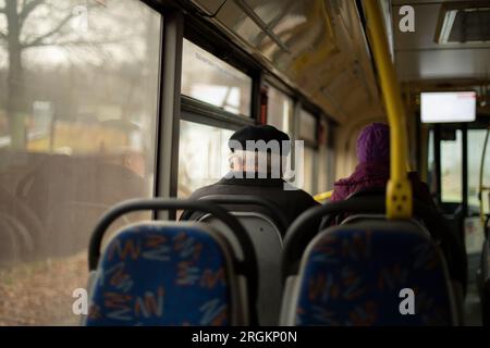 Leute im Bus. Passagiere sitzen während des Transports auf den Sitzen. Innerhalb der öffentlichen Verkehrsmittel. Sitzplätze im Bus. Stockfoto