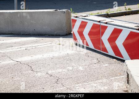 Warnung Straßenschild, Richtung Stadt abbiegen, auf einem Betonblock auf der Straße in der Ukraine abbiegen, Richtungsschild abbiegen Stockfoto