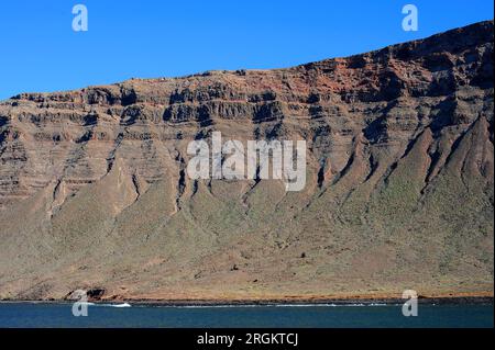 Riscos de Famara von der Insel La Graciosa aus gesehen. Lanzarote, Las Palmas, Kanarische Inseln, Spanien. Stockfoto