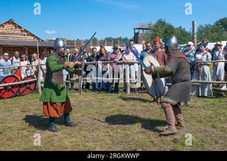 SHEVELEVO, RUSSLAND - 05. AUGUST 2023: Duell zweier Schwertkämpfer des frühen Mittelalters. Historisches Festival 'Prince's Brotherhood'. Region Nowgorod Stockfoto